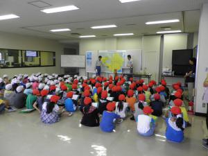 成田東小学校の皆さんが全体説明をうけている写真です