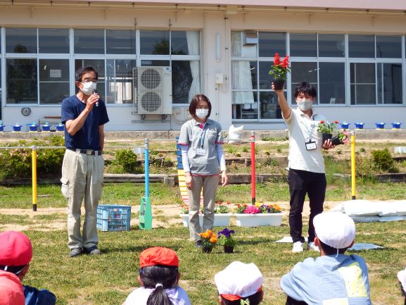 花の説明をする佐藤さん（写真左）