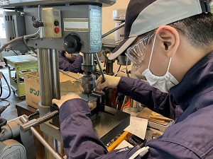 ボール盤で穴あけをしている様子